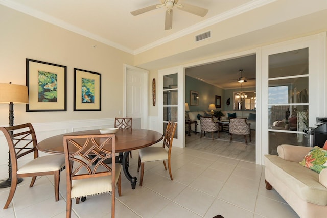 tiled dining space with ornamental molding and ceiling fan with notable chandelier