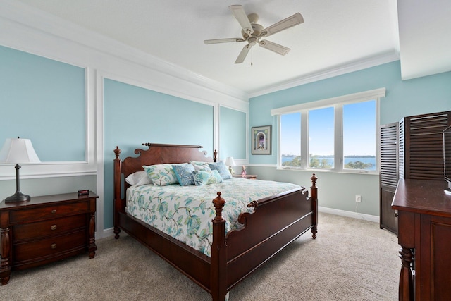 carpeted bedroom with crown molding and ceiling fan