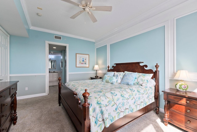 carpeted bedroom featuring crown molding, ceiling fan, and ensuite bath