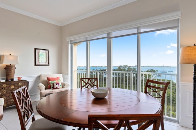 tiled dining area with ornamental molding, a water view, and a healthy amount of sunlight