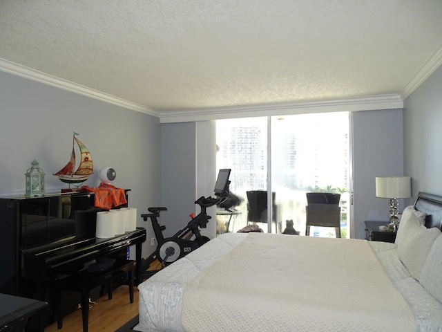 bedroom with hardwood / wood-style floors, a wall of windows, ornamental molding, and a textured ceiling