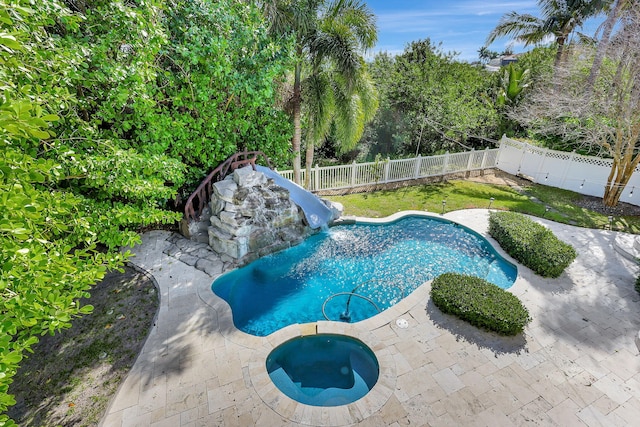 view of swimming pool featuring an in ground hot tub, a water slide, and a patio area