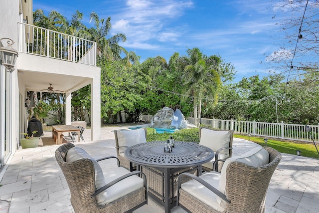 view of patio featuring ceiling fan and a balcony