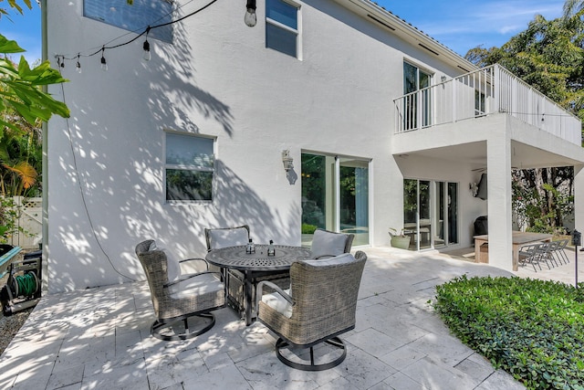 back of property with a balcony and a patio area