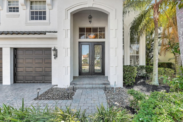 entrance to property with a garage and french doors