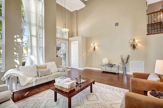 living room featuring hardwood / wood-style floors, a wealth of natural light, and a high ceiling