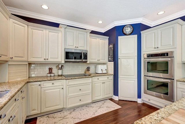 kitchen with tasteful backsplash, dark wood-type flooring, light stone countertops, and appliances with stainless steel finishes