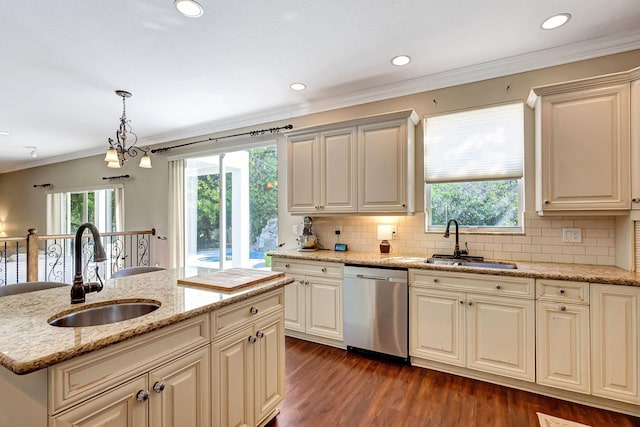 kitchen with a kitchen island with sink, sink, hanging light fixtures, and dishwasher