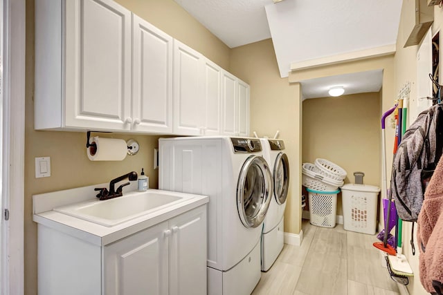 laundry room featuring sink, washing machine and dryer, and cabinets