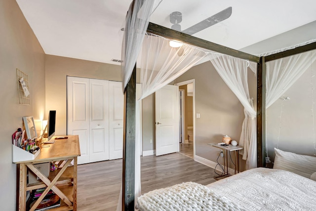 bedroom with hardwood / wood-style flooring, vaulted ceiling, and a closet