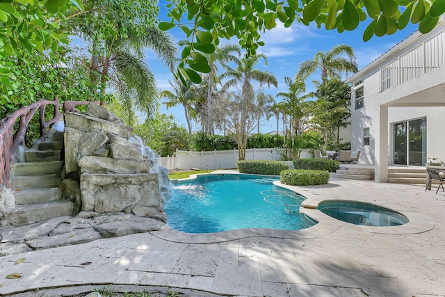 view of swimming pool featuring an in ground hot tub, pool water feature, and a patio