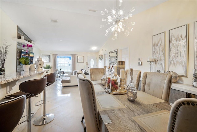 dining room with light tile patterned flooring, lofted ceiling, and a notable chandelier