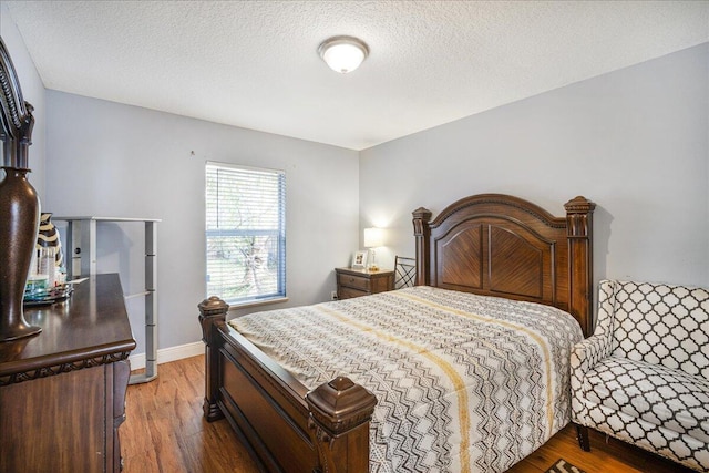 bedroom with wood-type flooring and a textured ceiling