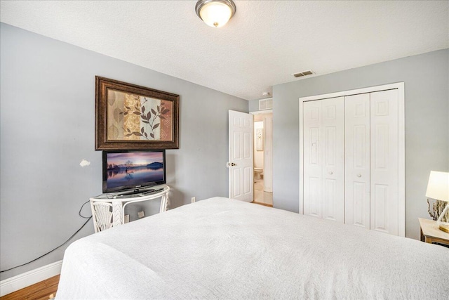 bedroom featuring a textured ceiling and a closet