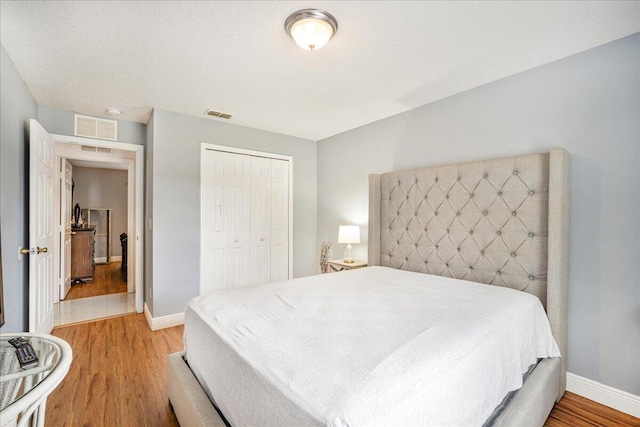 bedroom with light hardwood / wood-style flooring, a closet, and a textured ceiling