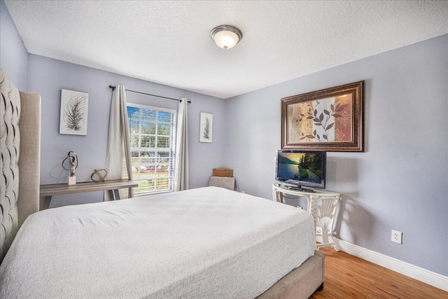 bedroom featuring wood-type flooring and a textured ceiling