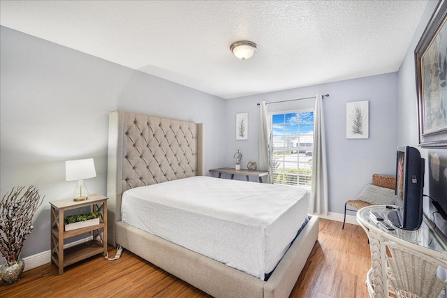 bedroom with hardwood / wood-style floors and a textured ceiling