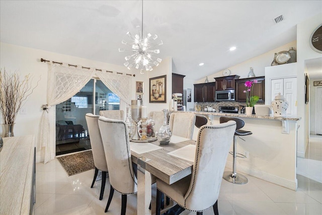 tiled dining room with vaulted ceiling and a chandelier