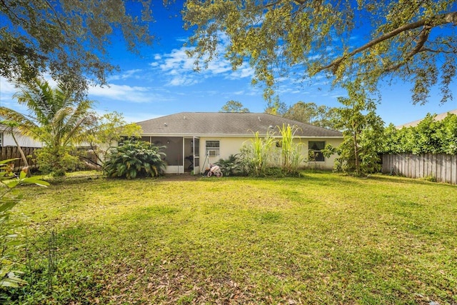 rear view of house with a lawn and a sunroom