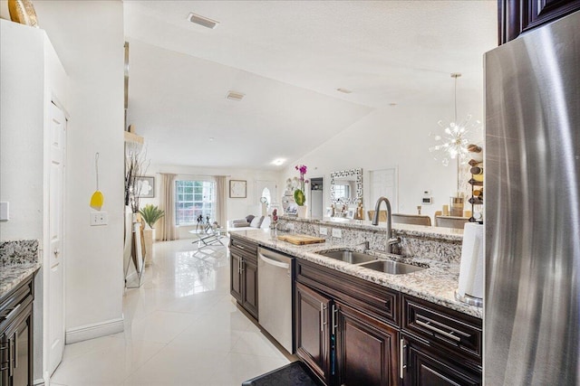 kitchen featuring light tile patterned flooring, sink, light stone counters, vaulted ceiling, and stainless steel appliances