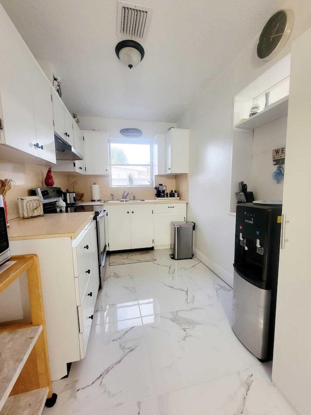 kitchen featuring sink, a textured ceiling, fridge, stainless steel electric stove, and white cabinets