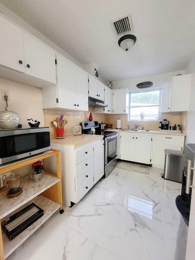 kitchen with stainless steel appliances, tasteful backsplash, sink, and white cabinets