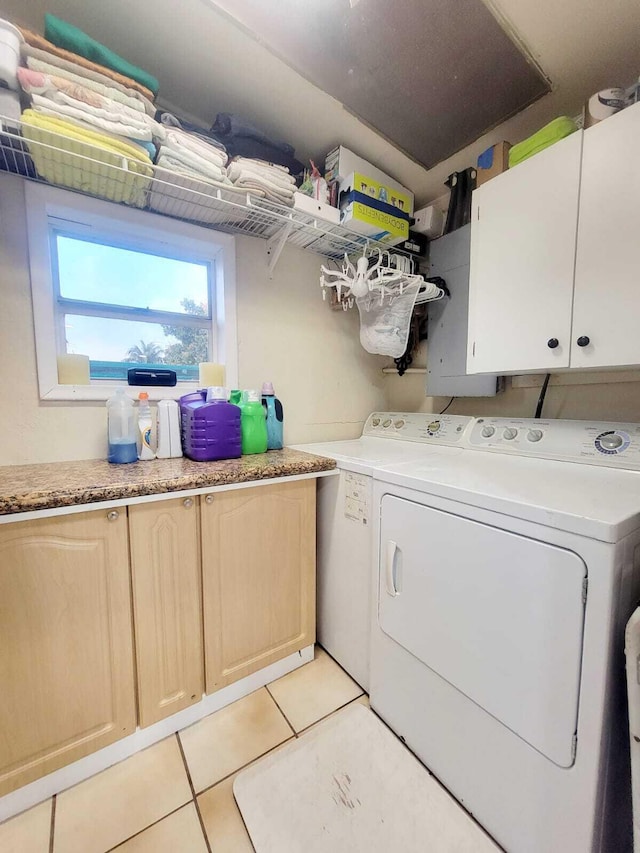 washroom with cabinets, light tile patterned floors, and washer and dryer