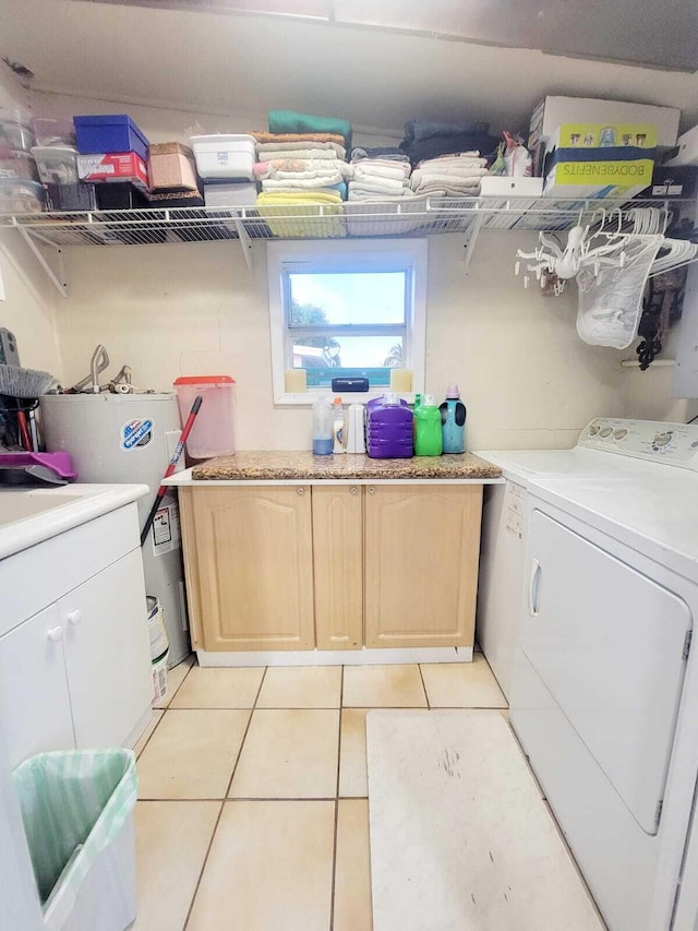 clothes washing area featuring washing machine and dryer, water heater, and light tile patterned floors