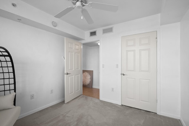 unfurnished bedroom with ceiling fan and light carpet