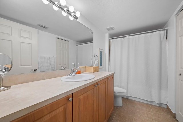 bathroom featuring tile patterned flooring, vanity, and toilet