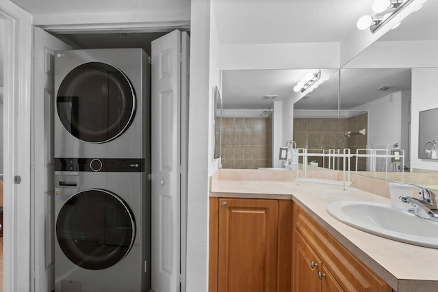 clothes washing area with stacked washer / dryer and sink