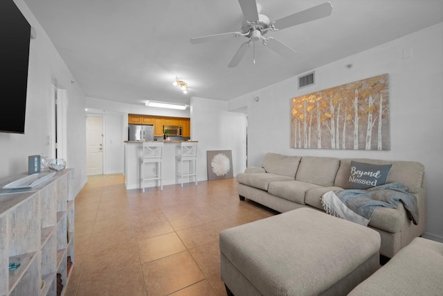 living room with light tile patterned floors and ceiling fan