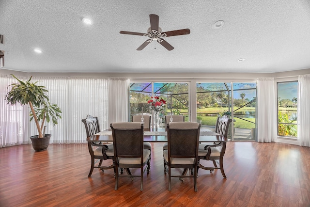 dining room with ceiling fan, dark wood-type flooring, and a textured ceiling