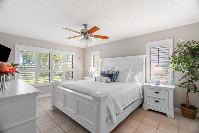 bedroom featuring ceiling fan, multiple windows, and a textured ceiling