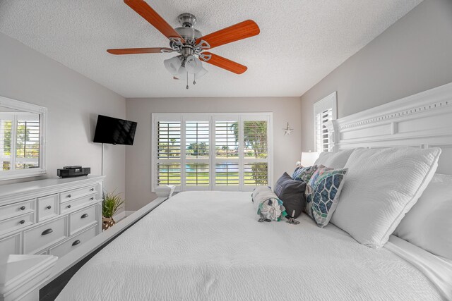 tiled bedroom featuring a textured ceiling, ceiling fan, and a closet