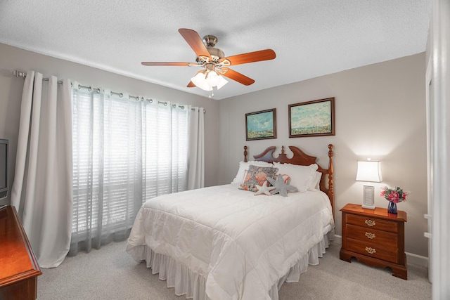 carpeted bedroom with ceiling fan and a textured ceiling