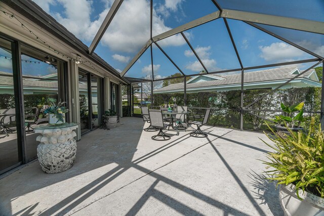 view of patio / terrace with a water view and a lanai