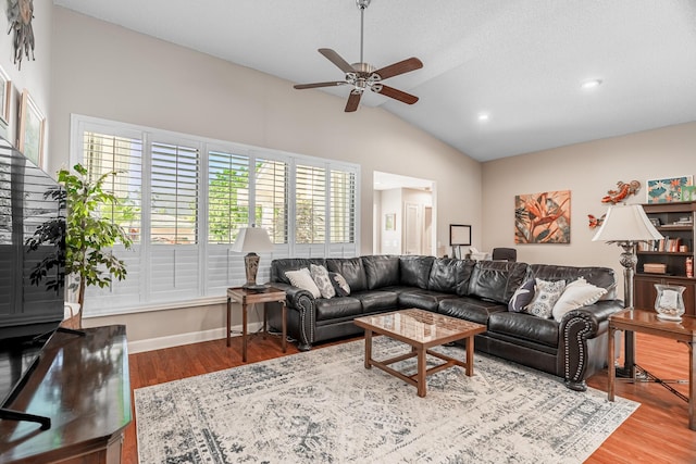 living area with vaulted ceiling, wood finished floors, baseboards, and ceiling fan
