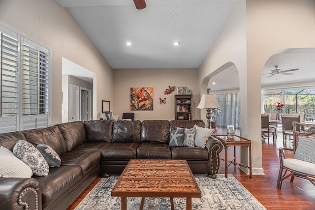 living room featuring hardwood / wood-style flooring, ceiling fan, and a textured ceiling