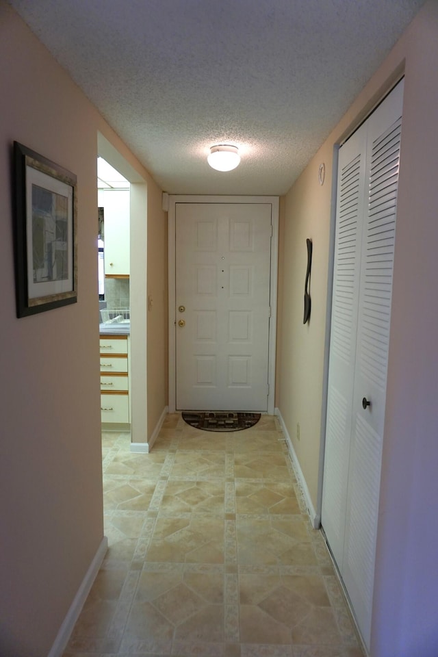 hall featuring a textured ceiling