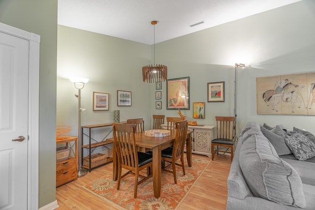 dining room featuring vaulted ceiling and light hardwood / wood-style floors