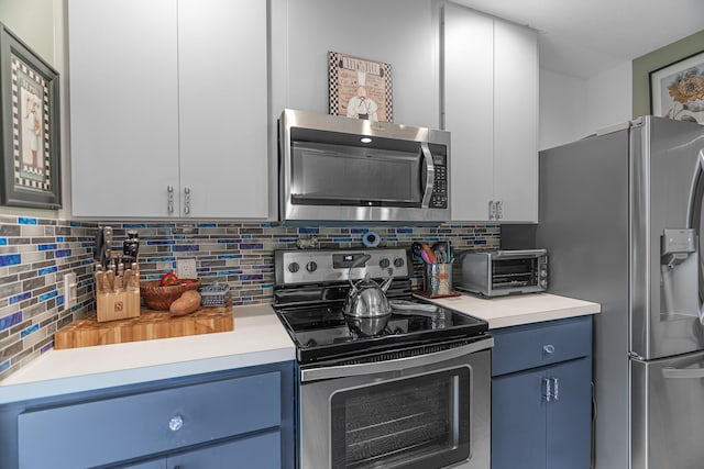 kitchen featuring blue cabinets, white cabinetry, appliances with stainless steel finishes, and tasteful backsplash