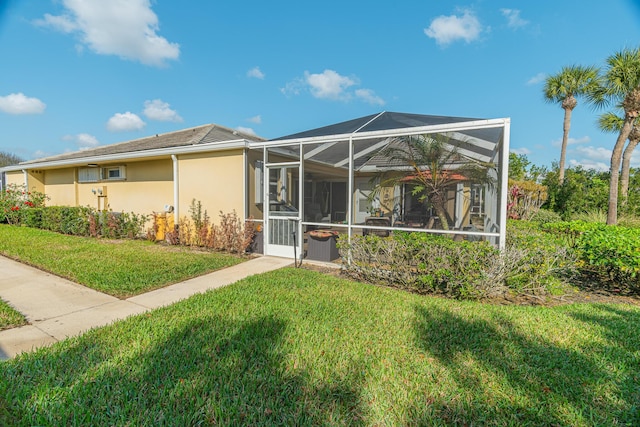 back of house featuring a lanai and a lawn