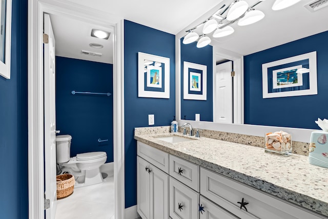 bathroom featuring vanity, tile patterned floors, and toilet