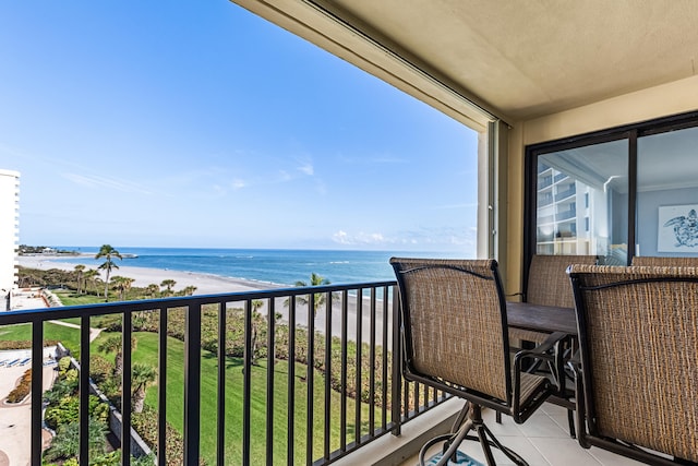 balcony featuring a view of the beach and a water view