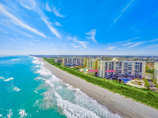 drone / aerial view with a water view and a beach view