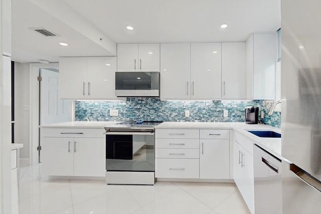 kitchen featuring sink, dishwasher, backsplash, white cabinets, and stainless steel range with electric cooktop