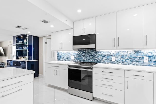 kitchen featuring backsplash, stainless steel appliances, and white cabinets