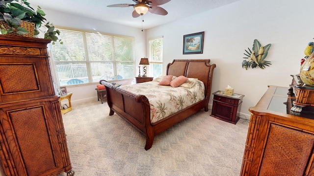 carpeted bedroom with multiple windows and ceiling fan