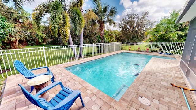 view of swimming pool featuring a patio and a lawn